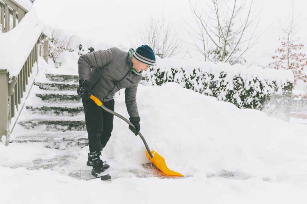 Schaufelnder Mann erleidet im Winter eine Verletzung